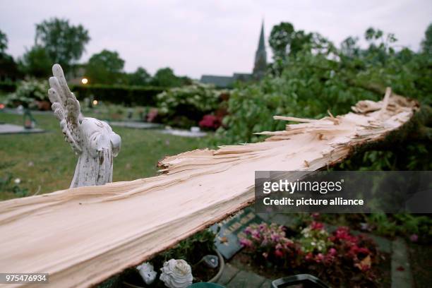 Dpatop - 16 May 2018, Germany, Schwalmtal: A fallen tree lying next to a destroyed angel figure ina garden. The tornado has, according to...