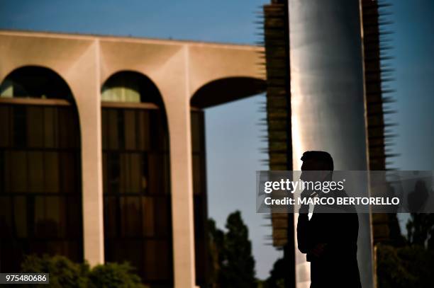 Man is silhouetted near the Mondadori building before the show of fashion house Ermenegildo Zegna during the Men's Spring/Summer 2019 fashion shows...