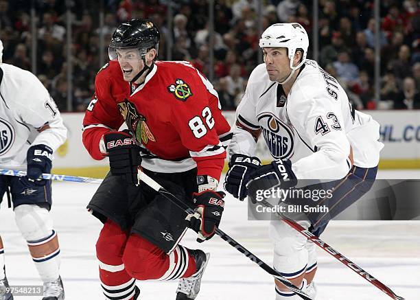 Tomas Kopecky of the Chicago Blackhawks and Jason Strudwick of the Edmonton Oilers watch for the puck on March 03, 2010 at the United Center in...