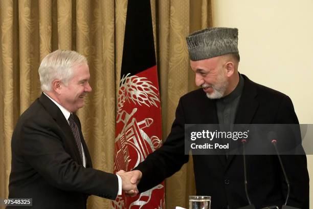 Secretary of Defense Robert Gates shakes hands with Afghanistan President Hamid Karzai during a press conference at The Presidential Palace March 8,...