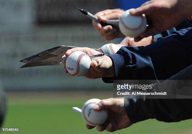 Fans offer baseballs for autographs as the New York Yankees host the Tampa Bay Rays March 5, 2010 at the George M. Steinbrenner Field in Tampa,...