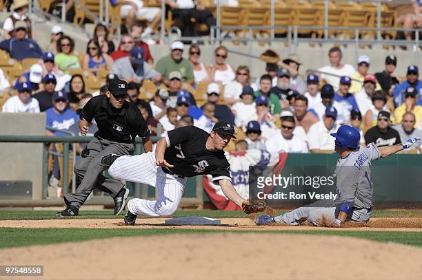 Jamey Carroll of the Los Angeles Dodgers steals third base avoiding the tag by Brent Morel of the Chicago White Sox on March 5, 2010 at The Ballpark...