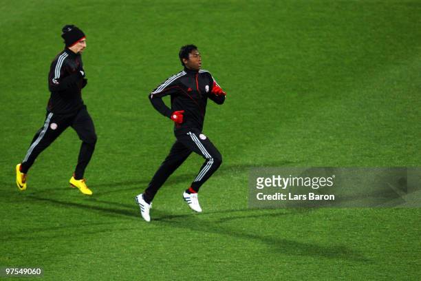 David Alaba warms up next to team mate Franck Ribery during a Bayern Muenchen training session at Artemio Franchi Stadium on March 8, 2010 in...