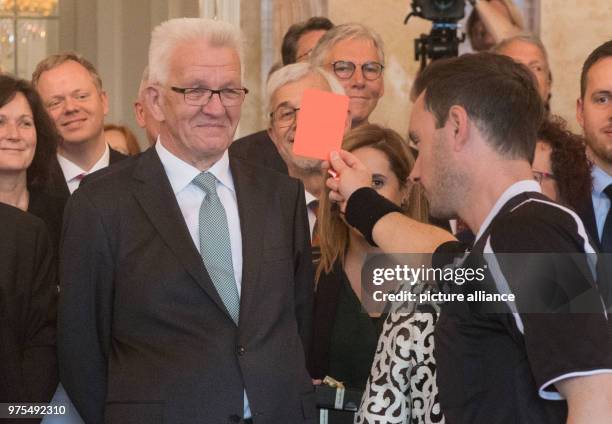 May 2018, Germany, Stuttgart: Choreographer and dancer Eric Gauthier shows a red card to Premier of Baden-Wuerttemberg Winfried Kretschmann during a...