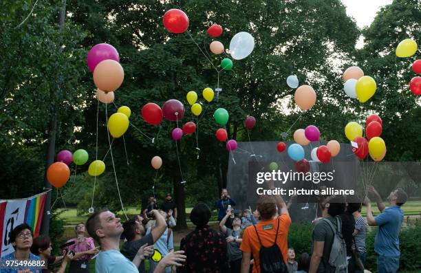 May 2018, Germany, Berlin: Coloured balloons ascend on the International Day Against Homophobia, Transphobia and Biphobia at the monument in...