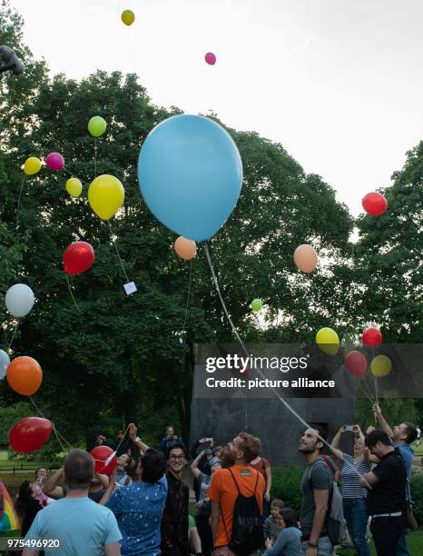 May 2018, Germany, Berlin: Coloured balloons ascend on the International Day Against Homophobia, Transphobia and Biphobia at the monument in...