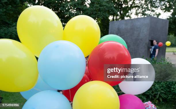 May 2018, Germany, Berlin: Coloured balloons ascend on the International Day Against Homophobia, Transphobia and Biphobia at the monument in...