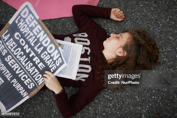 The placard reads 'Let's us defend the La Grave hospital against relocation'. Several ONGs as Act'up organized a die-in near the La Grave hospital in...