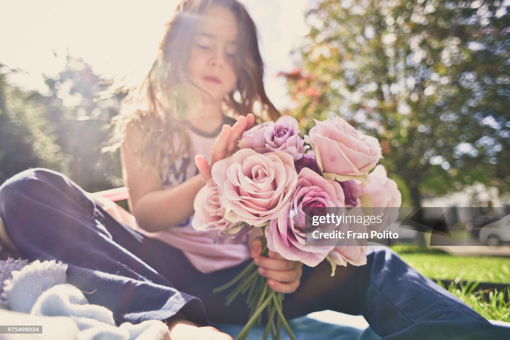 A girl playing with roses.