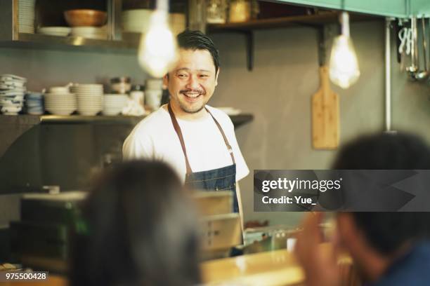 hombre cocinando en una cocina en pub japon - catering building fotografías e imágenes de stock