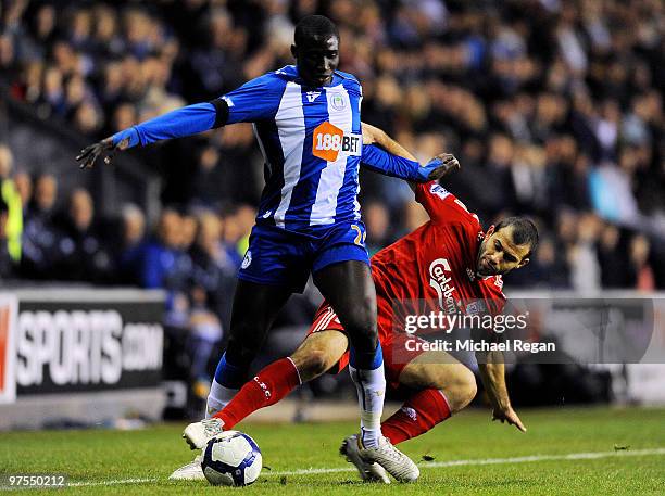 Mohamed Diame of Wigan competes for the ball with Javier Mascherano of Liverpool during the Barclays Premier League match between Wigan Athletic and...