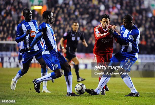 Maxi Rodriguez 2nd R of Liverpool competes for the ball with Titus Bramble of Wigan during the Barclays Premier League match between Wigan Athletic...