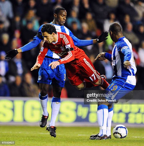 Maxi Rodriguez of Liverpool competes for the ball with Titus Bramble of Wigan during the Barclays Premier League match between Wigan Athletic and...