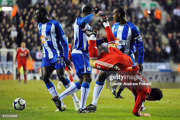 Maxi Rodriguez of Liverpool battles for the ball with Titus Bramble of Wigan during the Barclays Premier League match between Wigan Athletic and...