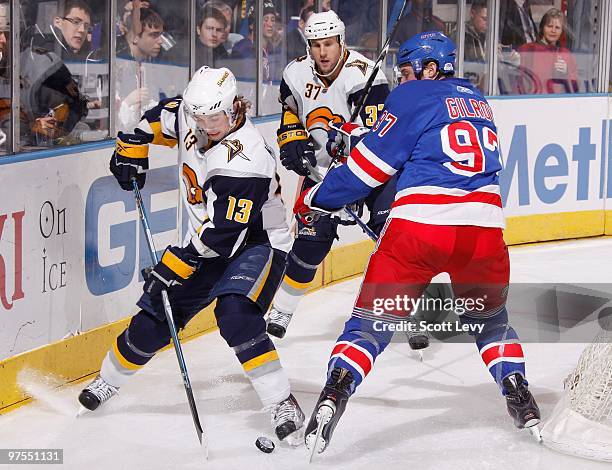 Tim Kennedy of the Buffalo Sabres skates with the puck behind the net against Matt Gilroy of the New York Rangers on March 7, 2010 at Madison Square...