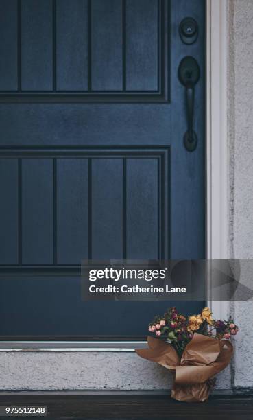 bouquet of dried roses left on doorstep of front door - portico sopraelevato foto e immagini stock