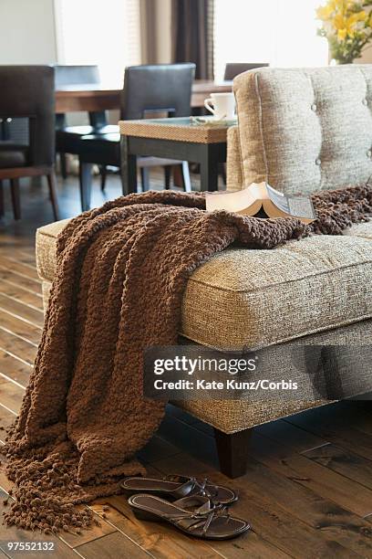 book, blanket and shoes in living room - chesterfield sofa stock pictures, royalty-free photos & images