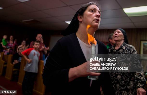 Robin Brandon holds fire to her neck as she spins during a Pentecostal serpent handlers service at the House of the Lord Jesus church in Squire, West...