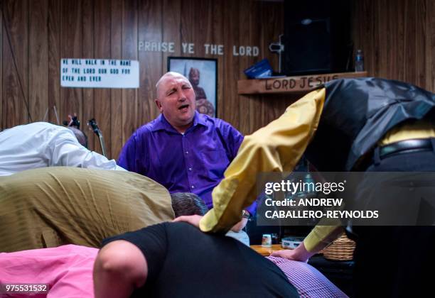 Pastor Chris Wolford prays as his feet are washed during a Pentecostal serpent handlers service at the House of the Lord Jesus church in Squire, West...