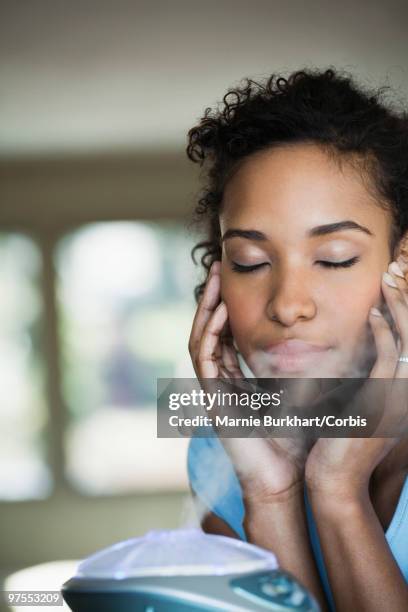 woman sitting by humidifier - humidifier stock pictures, royalty-free photos & images