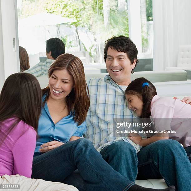 family hanging out on sofa - chesterfield sofa stock pictures, royalty-free photos & images