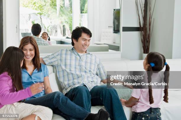 family hanging out on sofa - chesterfield sofa stock pictures, royalty-free photos & images