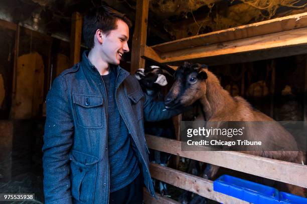Chicago Academy for the Arts ballet student Zachary Jeppsen feeds a pen of goats at his family's farm in Whitewater, Wis. On Monday, Dec. 18, 2017....