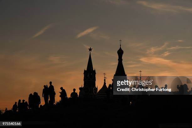 Football fans, tourists and The Kremlin is silhouetted at sunset during The World Cup tournament n June 15, 2018 in Moscow, Russia. Russia won the...
