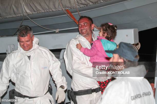 Some soldiers of Guardia di Finanza with a child during landing of 48 Syrian refugees landed at the Port of Crotone in the night, transported by a...