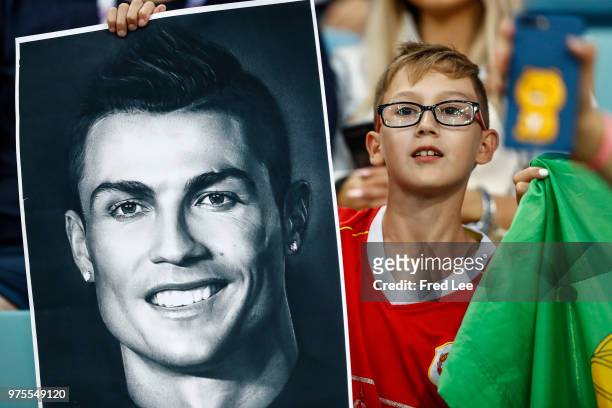 Young fan holds a photo of as Cristiano Ronaldo of Portugal as he enjoys the pre match atmosphere prior to the 2018 FIFA World Cup Russia group B...