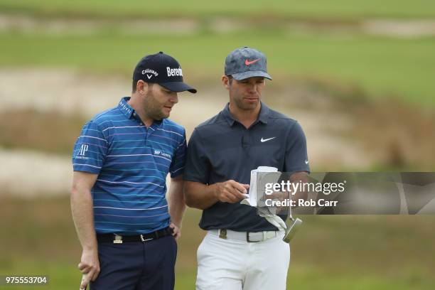 Branden Grace of South Africa and Paul Casey of England talk on the sixth green during the second round of the 2018 U.S. Open at Shinnecock Hills...