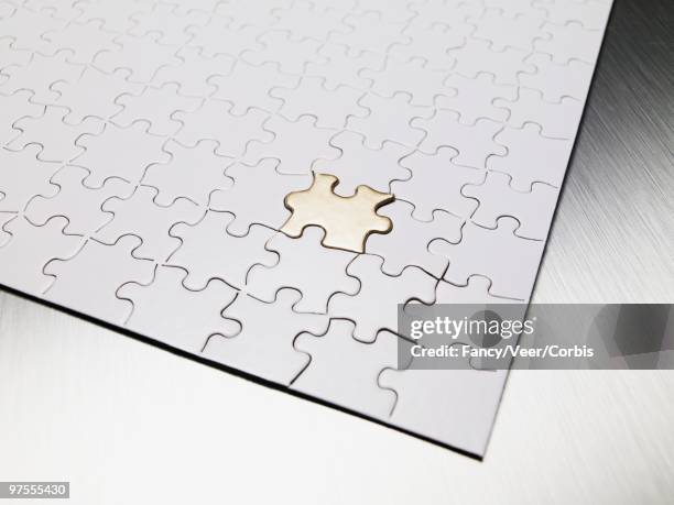 gold puzzle piece - dernière pièce du puzzle photos et images de collection