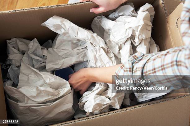 woman unpacking cardboard box - broken mug stock pictures, royalty-free photos & images