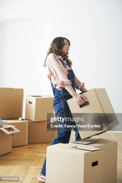 woman lifting cardboard box - box lifting technique stock-fotos und bilder