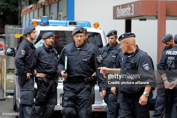 June 2018, Germany, Cologne: Police officers standing before the residential complex Osloerstr. 3 in Cologne-Chorweiler. The police is searching on...