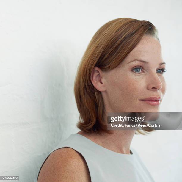 woman leaning against wall - ärmelloses oberteil stock-fotos und bilder