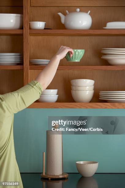 woman putting away dishes - tidy room fotografías e imágenes de stock