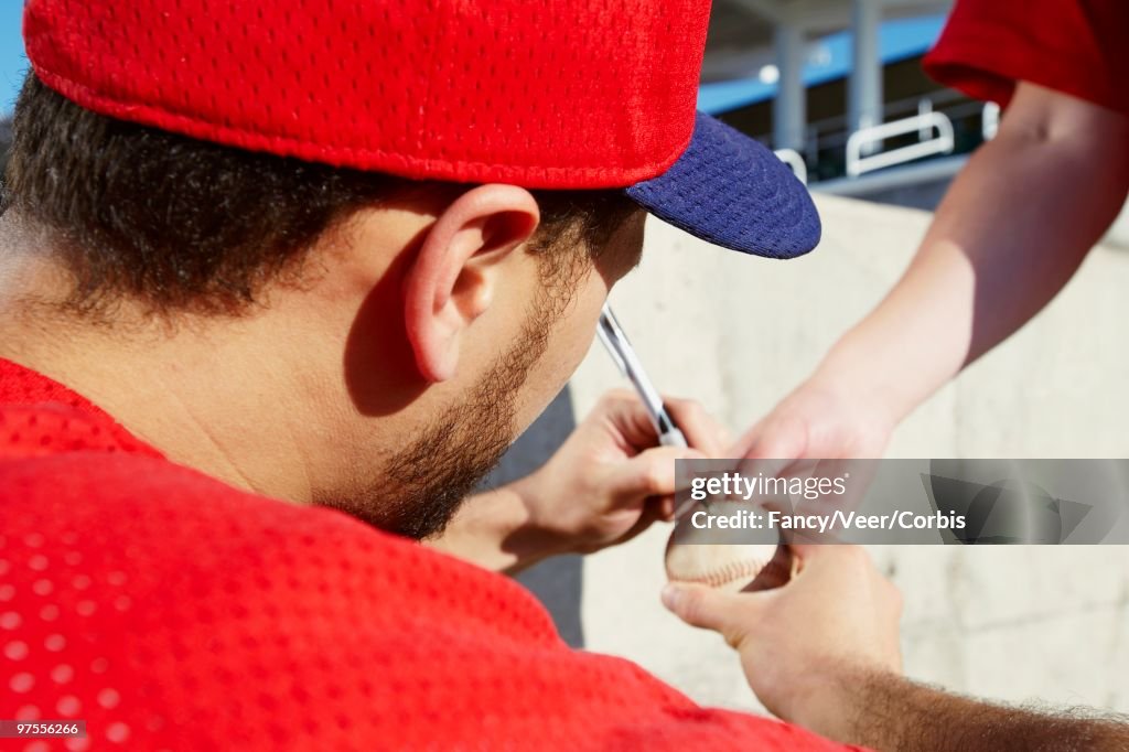 Baseball player signing baseball