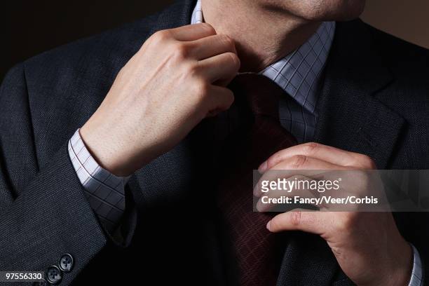 businessman adjusting necktie - collar stock pictures, royalty-free photos & images