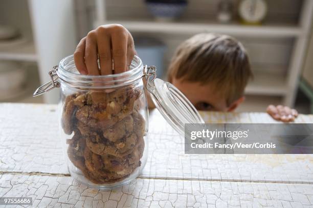 boy snitching a cookie - stealing cookie stock pictures, royalty-free photos & images