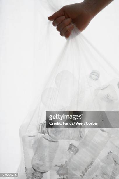 throwing out trash bag full of plastic water bottles - full responsibility stock pictures, royalty-free photos & images