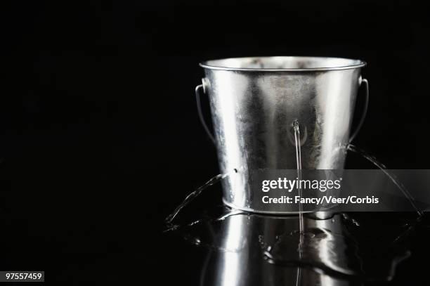 water pouring out of holes in bucket - bucket stock pictures, royalty-free photos & images