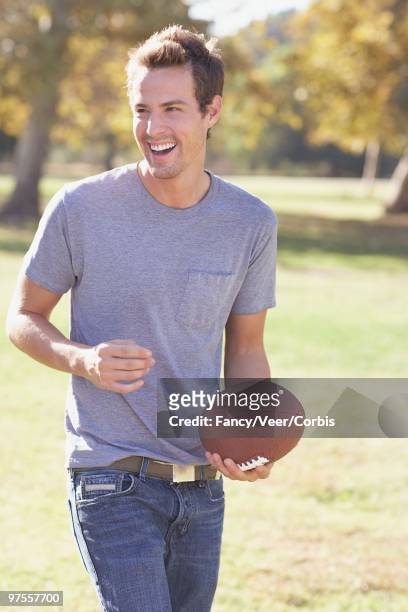 man playing football at the park - american football uniform stock pictures, royalty-free photos & images