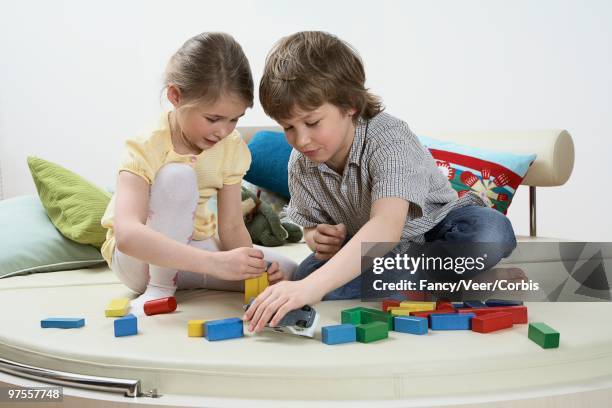 brother and sister playing with toy blocks - boys wearing tights stock-fotos und bilder