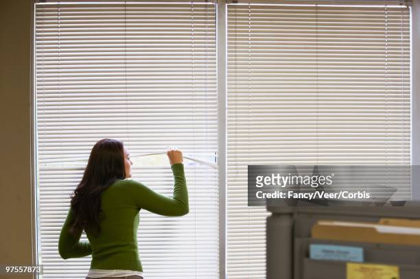 woman peeking through blinds - golf cheating foto e immagini stock