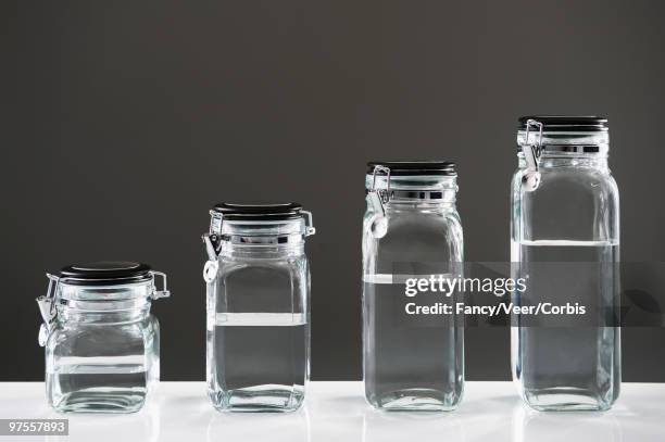 clear liquid in jars - odd one out obscure stock-fotos und bilder