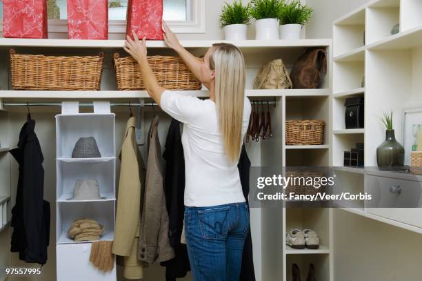 woman tidying walk-in closet - positioned stock pictures, royalty-free photos & images