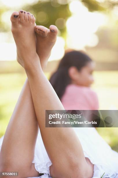 woman relaxing outdoors - woman lying on stomach with feet up stock pictures, royalty-free photos & images