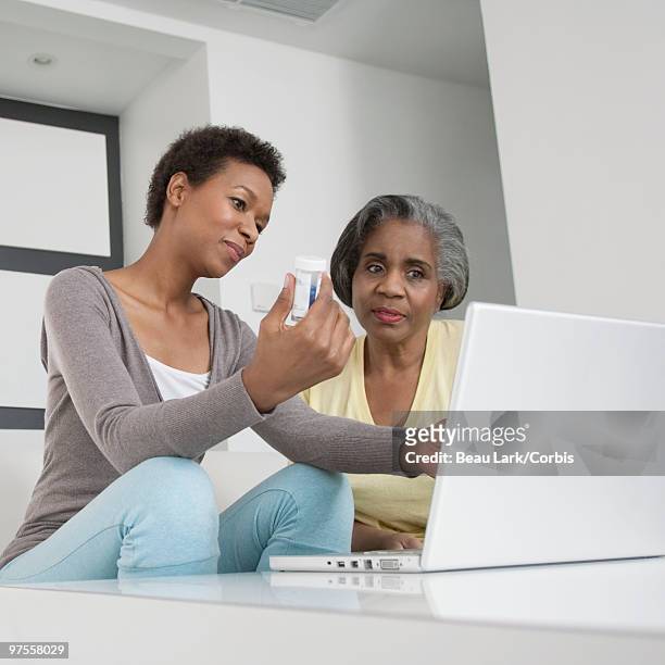 daughter showing mother how to refill prescription - corbiscom stock pictures, royalty-free photos & images