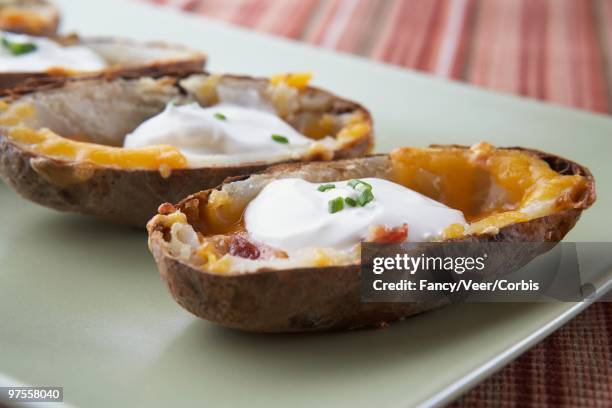 potato skins with cheese and sour cream - halved potato stock pictures, royalty-free photos & images